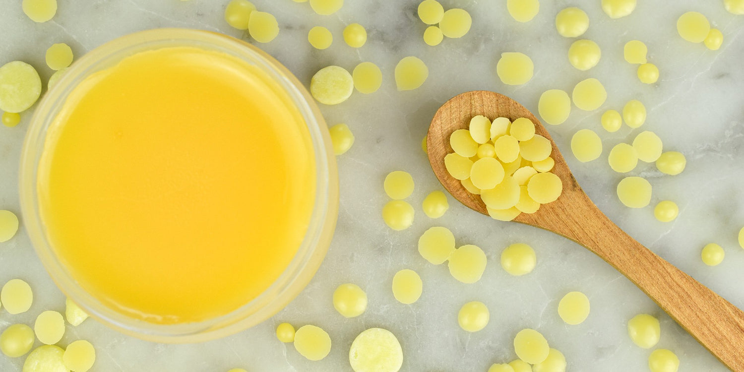 Sfeerfoto DIY beautybalm. Met cacaoboter en candelillawas op marmer met houten lepel.